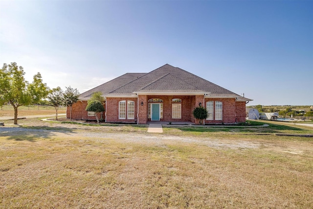 view of front facade featuring brick siding and a front yard