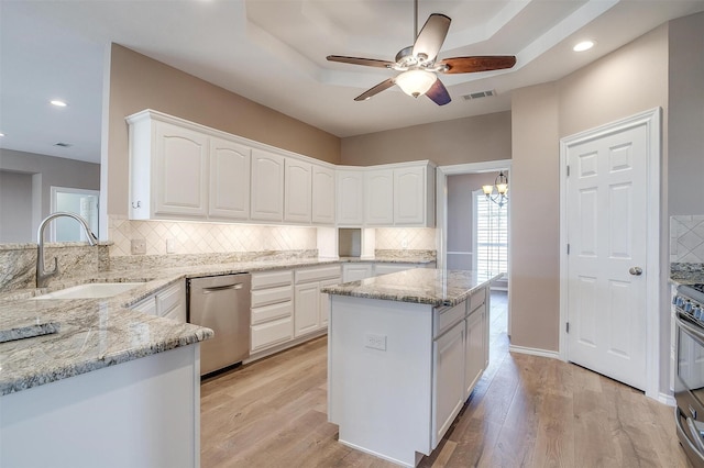 kitchen with visible vents, light wood-style flooring, appliances with stainless steel finishes, light stone countertops, and a sink