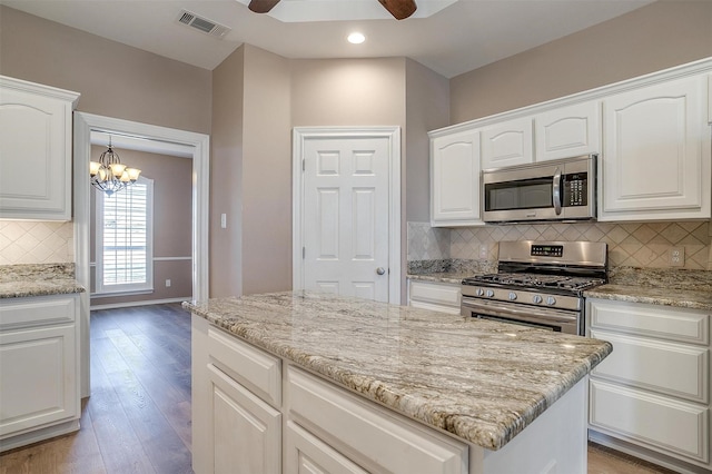 kitchen featuring appliances with stainless steel finishes, visible vents, and white cabinetry