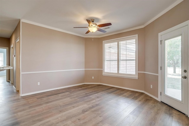 empty room featuring light wood-type flooring, a healthy amount of sunlight, visible vents, and crown molding