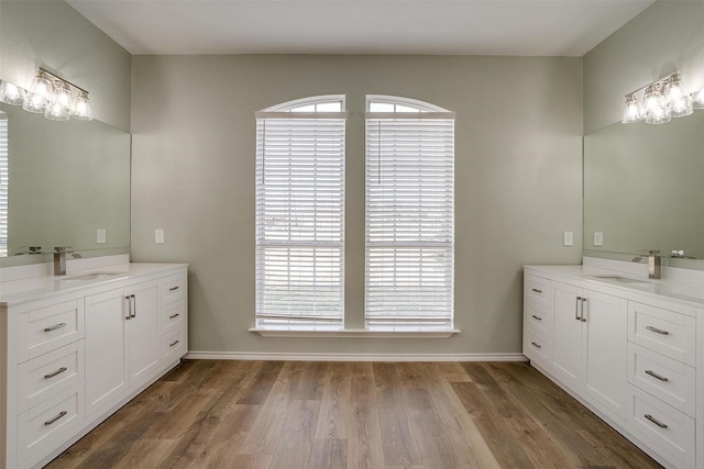 full bath with a wealth of natural light, a sink, and wood finished floors