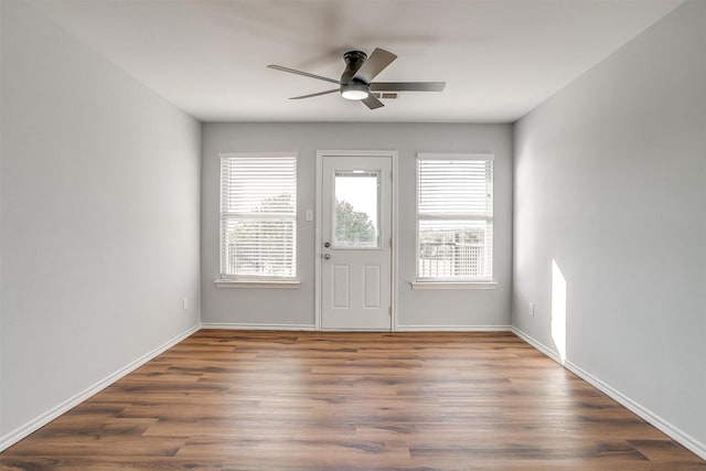 foyer featuring wood finished floors, a ceiling fan, and baseboards