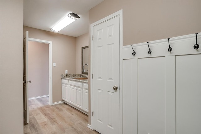 bathroom with wood finished floors, vanity, and baseboards