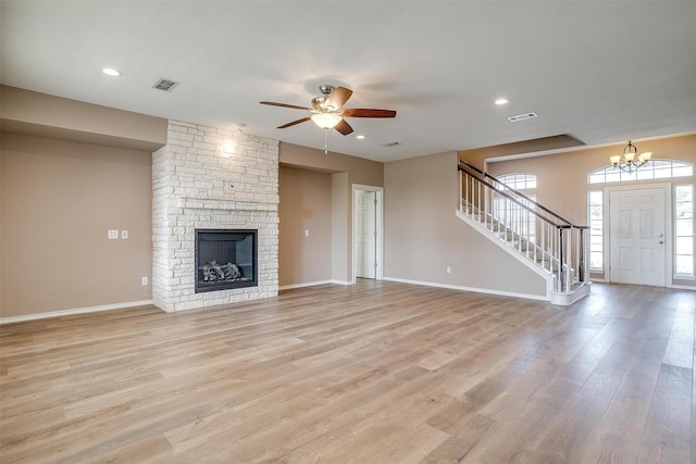 unfurnished living room featuring stairs, light wood-type flooring, visible vents, and baseboards