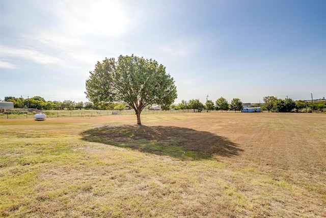 view of yard with fence and a rural view