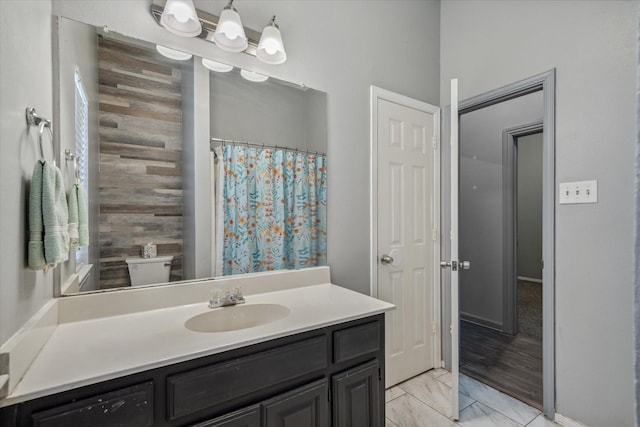 full bath featuring marble finish floor, vanity, and a shower with shower curtain