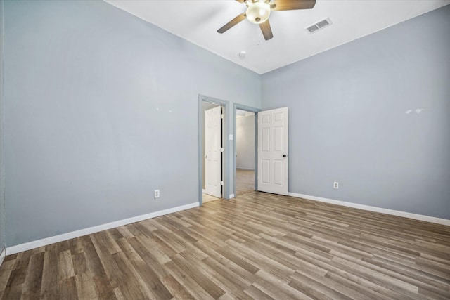 unfurnished room with visible vents, ceiling fan, baseboards, and wood finished floors