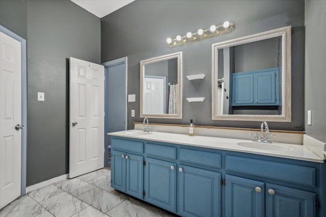 bathroom featuring marble finish floor, a sink, and double vanity