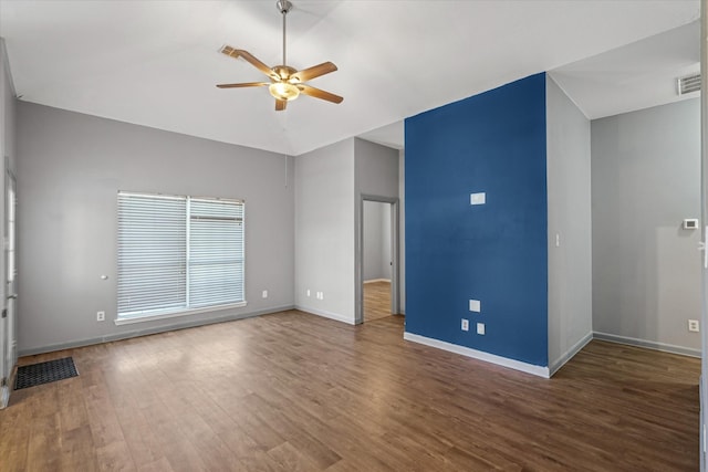 interior space featuring visible vents, vaulted ceiling, ceiling fan, wood finished floors, and baseboards