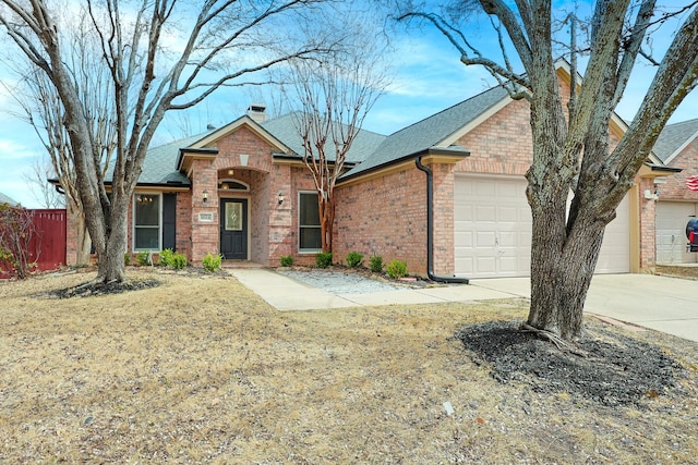 ranch-style home featuring concrete driveway, a chimney, an attached garage, fence, and brick siding