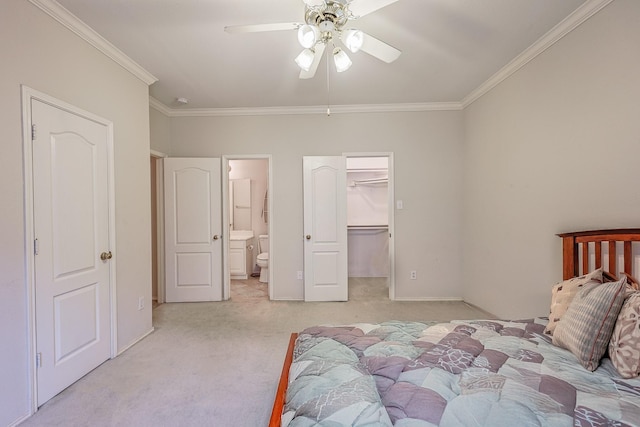 carpeted bedroom with ceiling fan, baseboards, a spacious closet, ornamental molding, and ensuite bath