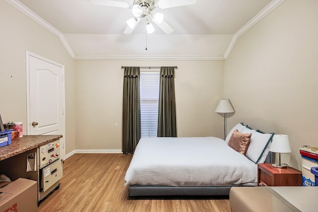 bedroom featuring baseboards, light wood finished floors, vaulted ceiling, and crown molding