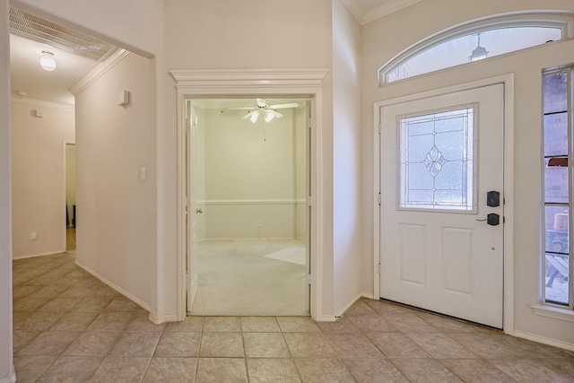 entrance foyer with light tile patterned flooring, crown molding, and baseboards