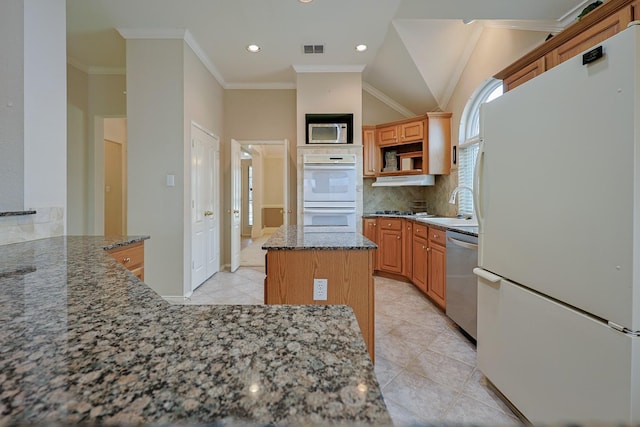 kitchen featuring tasteful backsplash, visible vents, appliances with stainless steel finishes, a sink, and dark stone counters