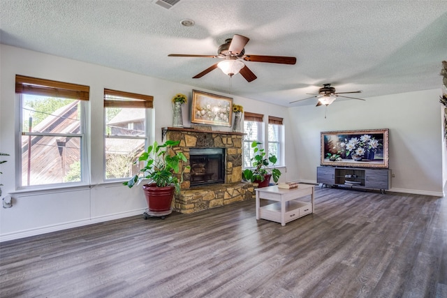 2412 Cedar Crest Dr, Granbury, TX 76048 - living room featuring a stone fireplace, a ceiling fan, wood finished floors, and a textured ceiling