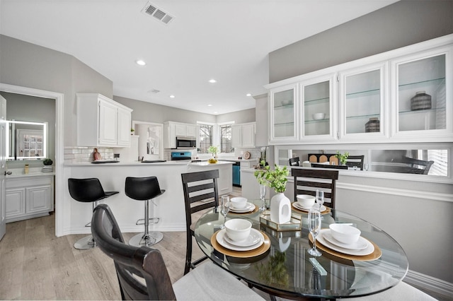 dining area with light wood finished floors, visible vents, and recessed lighting