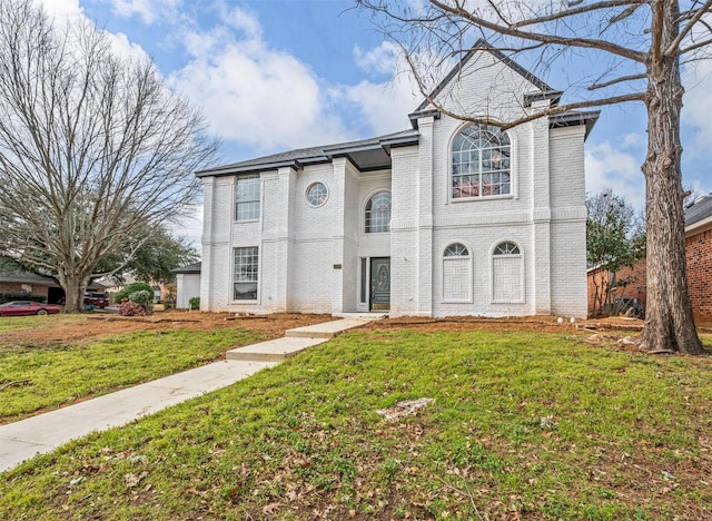 view of front of house with brick siding and a front yard