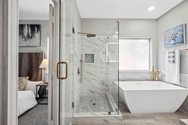 ensuite bathroom featuring a freestanding bath, ensuite bath, and a marble finish shower