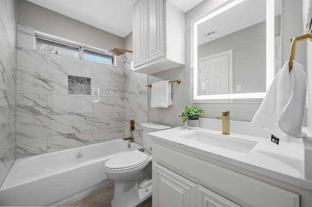 full bathroom with visible vents, toilet, washtub / shower combination, vanity, and wood finished floors