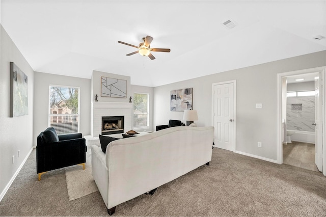 living room with baseboards, visible vents, light colored carpet, ceiling fan, and a brick fireplace