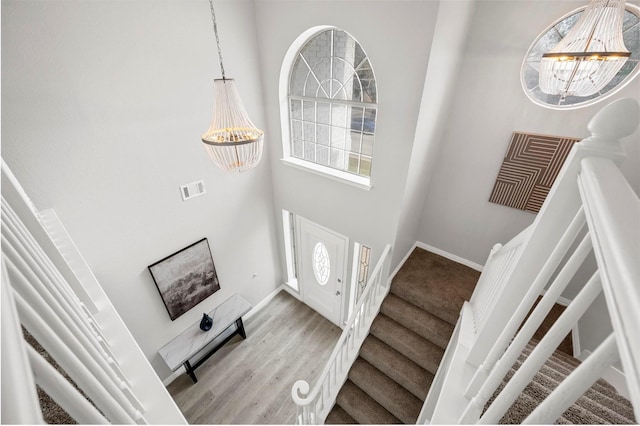 foyer entrance with an inviting chandelier, stairway, visible vents, and a wealth of natural light