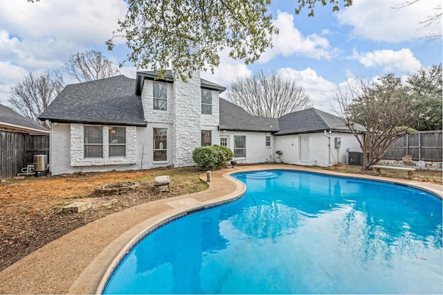 view of swimming pool with a fenced backyard, central AC unit, and a fenced in pool