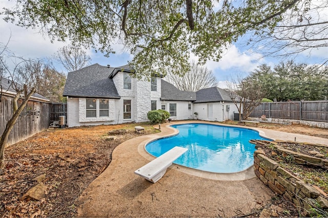 view of pool featuring a diving board, a fenced backyard, and a fenced in pool