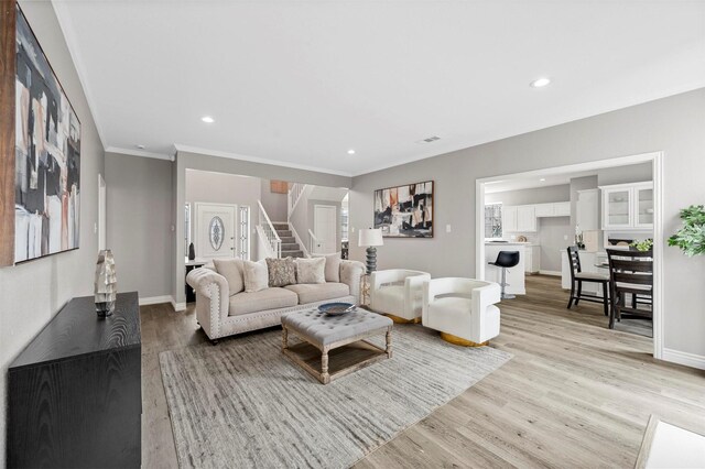 living room with stairs, baseboards, light wood-style flooring, and recessed lighting