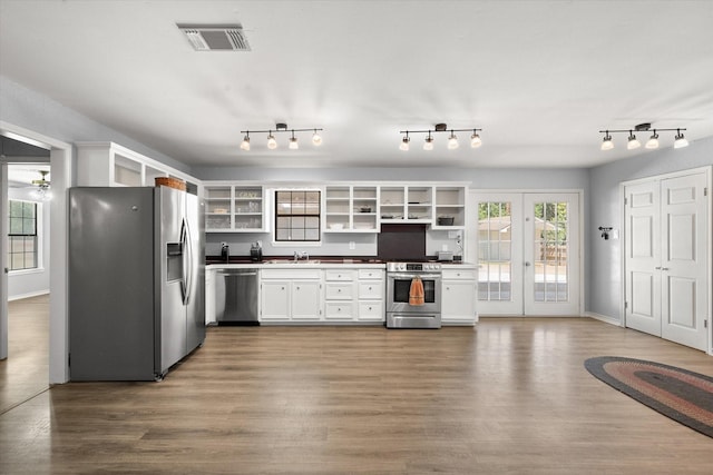 kitchen featuring stainless steel appliances, a sink, wood finished floors, visible vents, and open shelves