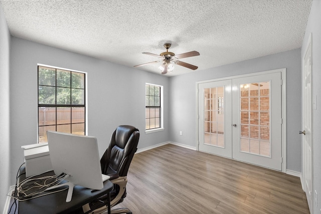 office featuring a textured ceiling, wood finished floors, a ceiling fan, baseboards, and french doors