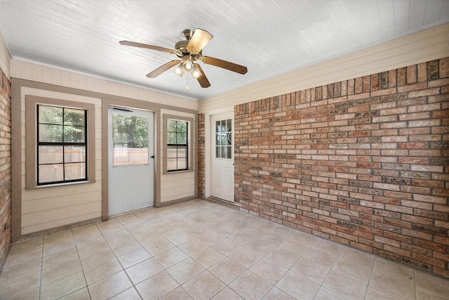 unfurnished sunroom featuring a ceiling fan