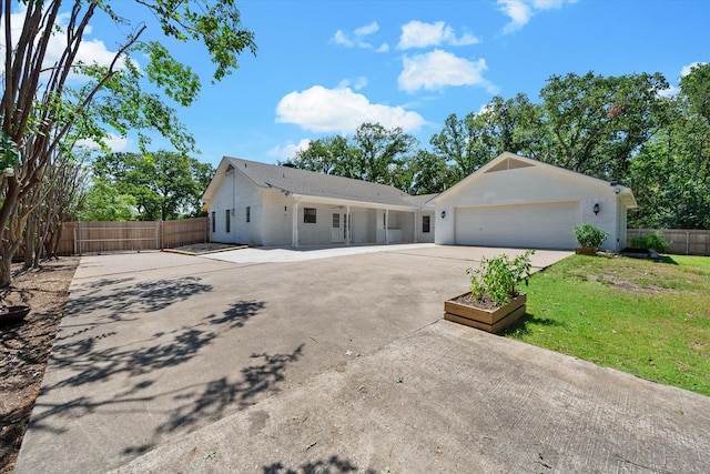 ranch-style home featuring a garage, fence, concrete driveway, and a front yard