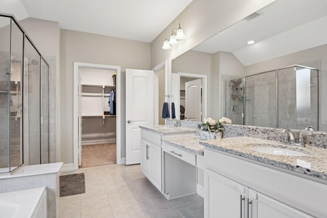 bathroom with lofted ceiling, a shower stall, a walk in closet, and a sink