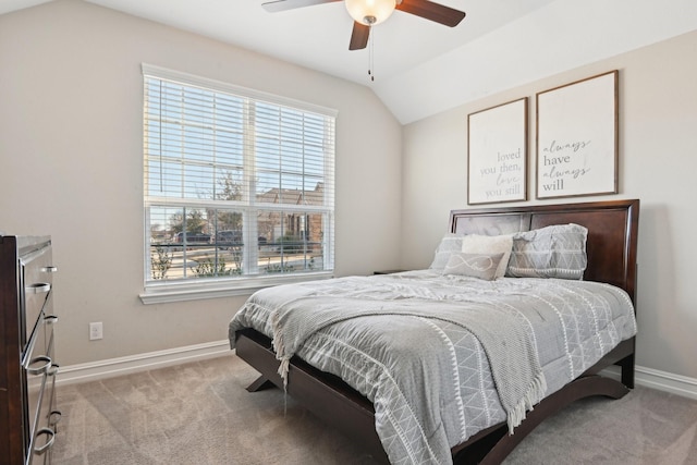 carpeted bedroom featuring vaulted ceiling, multiple windows, a ceiling fan, and baseboards