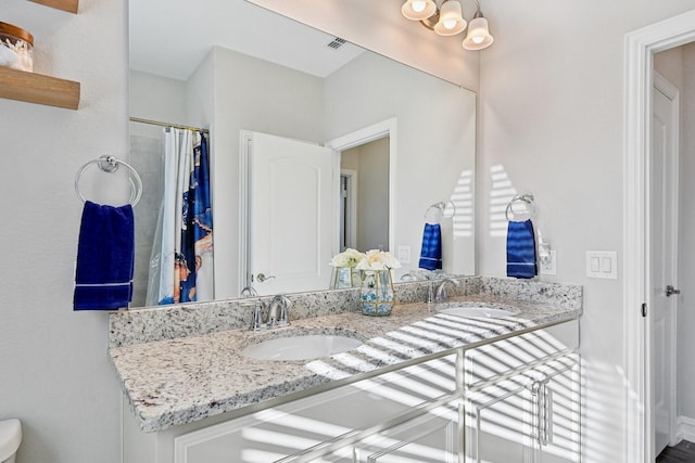 bathroom featuring double vanity, a sink, and visible vents