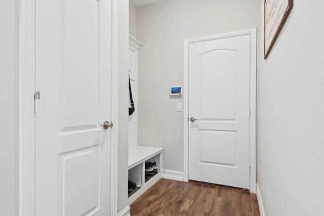 mudroom with dark wood finished floors and baseboards