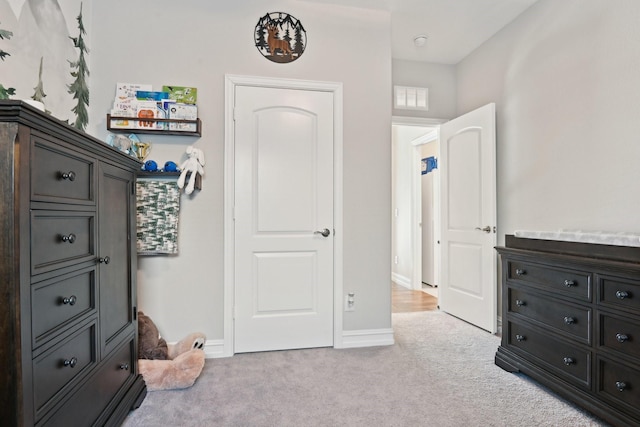 bedroom featuring light carpet, visible vents, and baseboards