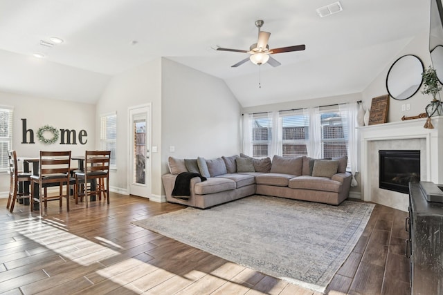 living area with wood finished floors, visible vents, and a healthy amount of sunlight