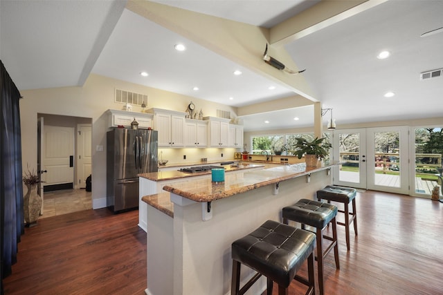 928 N Irving Heights Dr, Irving, TX 75061 - kitchen featuring light stone countertops, visible vents, appliances with stainless steel finishes, and a breakfast bar area