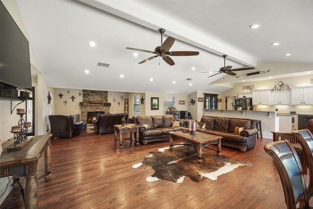 928 N Irving Heights Dr, Irving, TX 75061 - living area with lofted ceiling with beams, a stone fireplace, visible vents, a ceiling fan, and dark wood-style floors