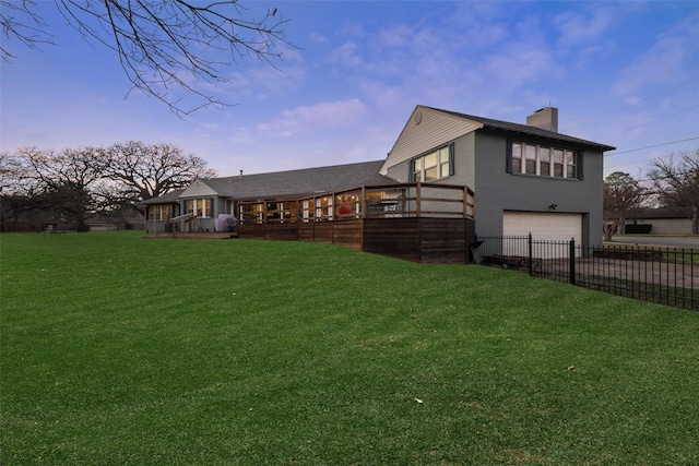 928 N Irving Heights Dr, Irving, TX 75061 - rear view of house with a chimney, a lawn, an attached garage, driveway, and a wooden deck
