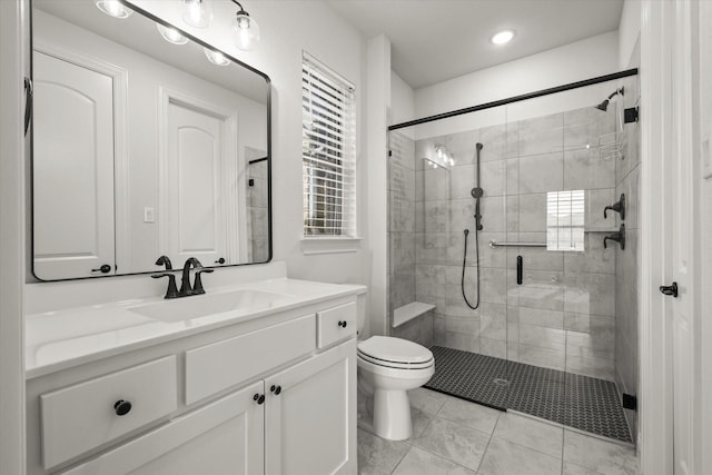 bathroom featuring toilet, a stall shower, and vanity