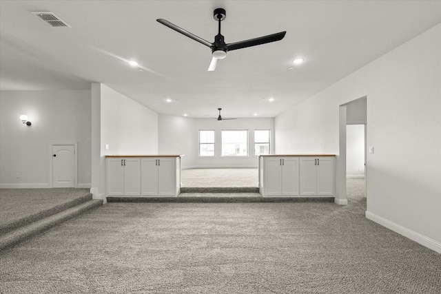 unfurnished room featuring ceiling fan, carpet floors, visible vents, and baseboards