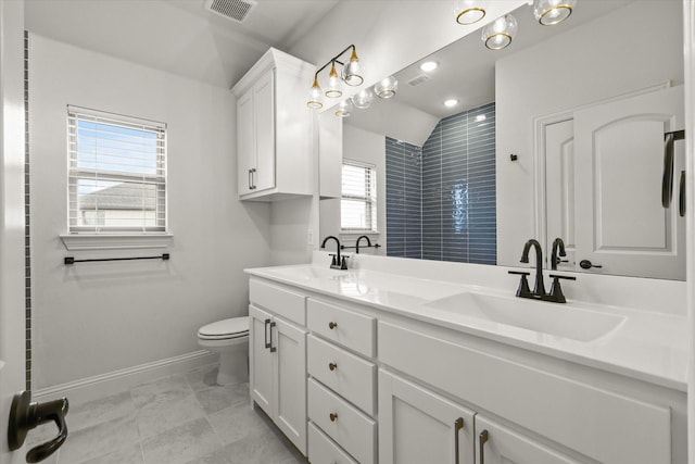 full bath featuring double vanity, a sink, visible vents, and baseboards