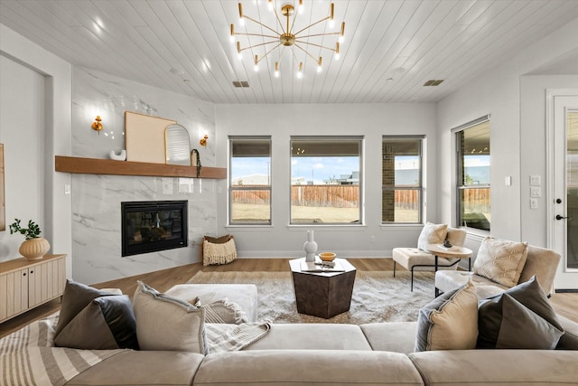 living room featuring wooden ceiling, visible vents, a fireplace, and wood finished floors