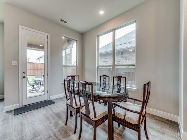 dining room with light wood-style floors, visible vents, and baseboards