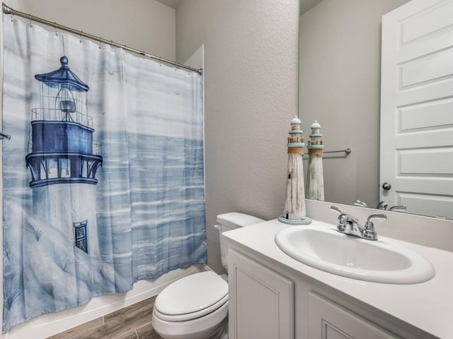 full bathroom with shower / bath combination with curtain, a textured wall, toilet, vanity, and wood finished floors