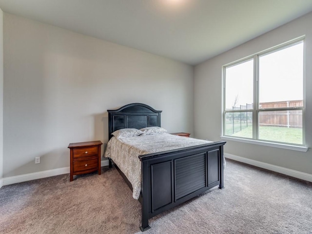 bedroom with baseboards and light colored carpet