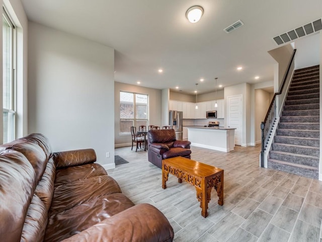 living area featuring stairs, visible vents, and recessed lighting