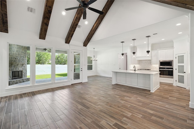 unfurnished living room featuring light wood-type flooring, high vaulted ceiling, visible vents, and beam ceiling